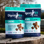 Two packages of Digestive K9 Chews on a wooden surface with a blurred natural background.